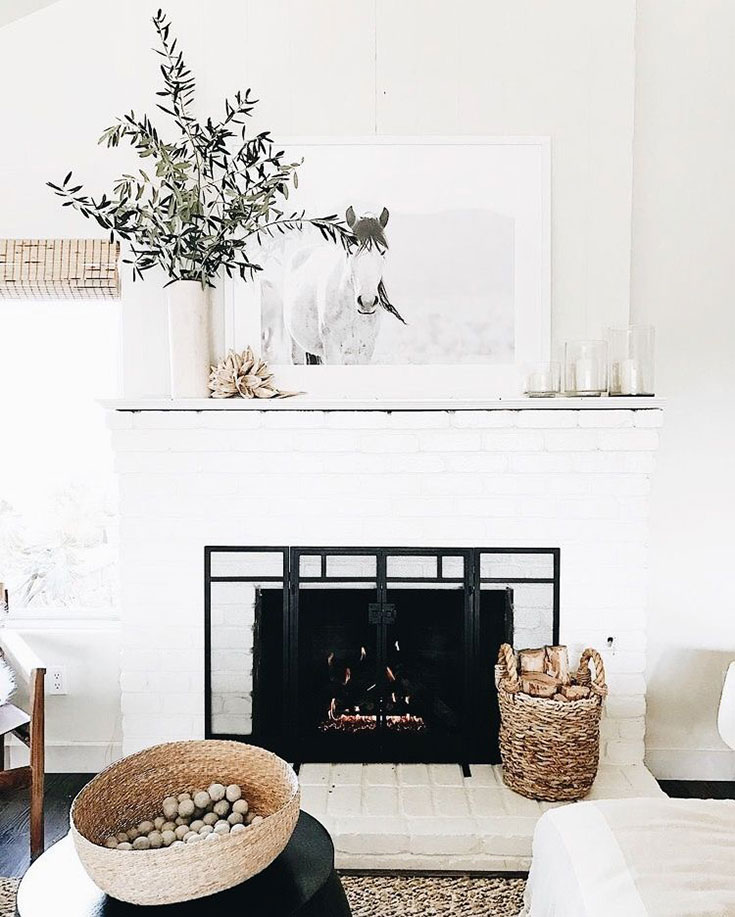 Cozy white fireplace with woven basket holding firewood. Thanks for sharing!