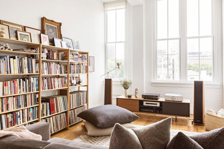 Throw pillows piled on the floor in one bedroom apartment.