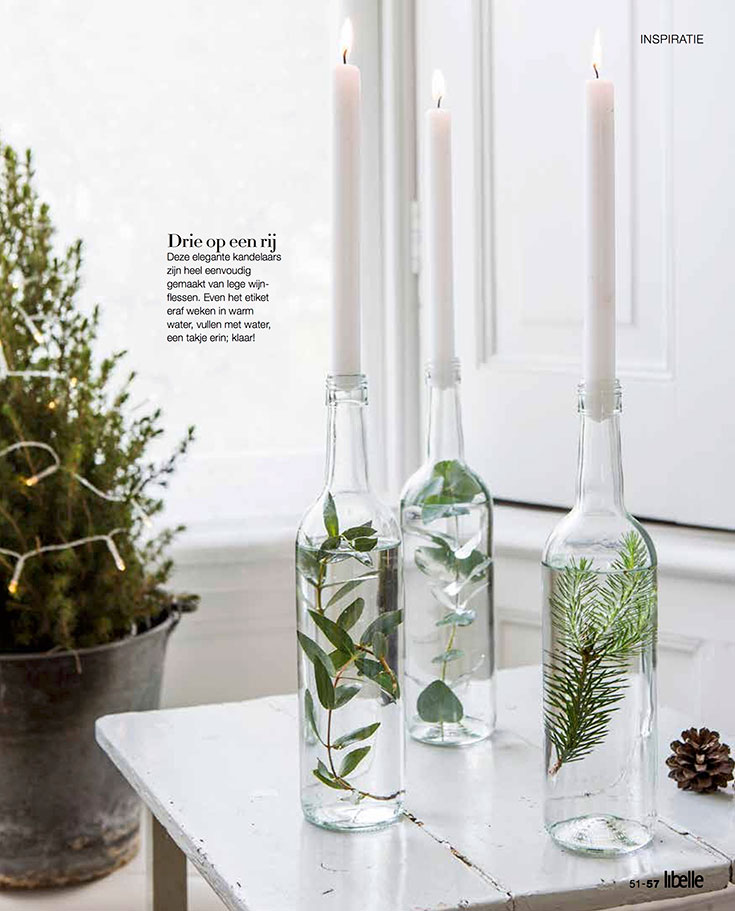 An easy holiday DIY. A wine bottle filled with water and greenery. Turned into a candle holder.