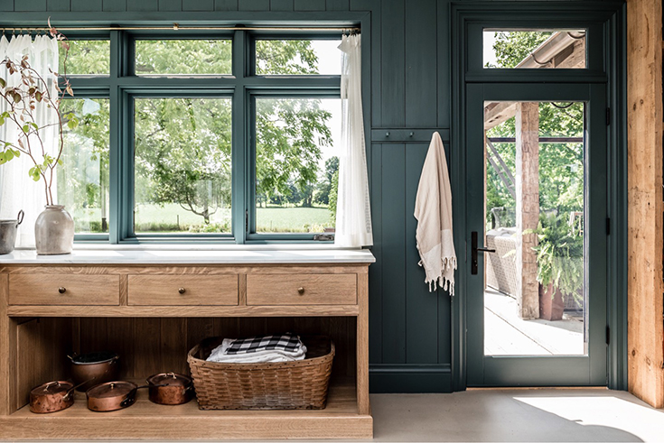 Gorgeous deep dark green interior with light pine furniture. Design by Angela Wheeler