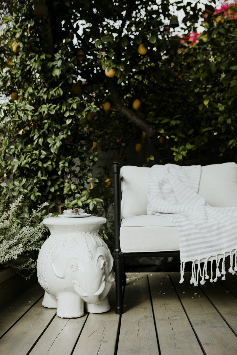 Outdoor+Living+Space_white+pillow+wrought+iron+sofa+pergola+lush+greenery+deck+ceramic+elephant.jpg