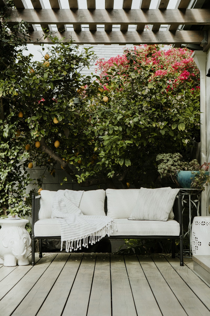 Outdoor+Living+Space_white+pillow+wrought+iron+sofa+pergola+lush+greenery+deck+ceramic+elephant.jpg