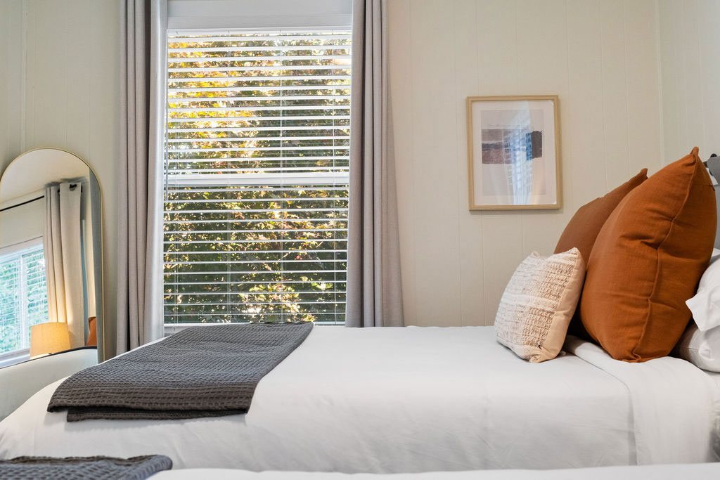 Gorge Getaway bedroom today with rust pillows and a gray throw